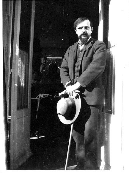 Claude Debussy en 1909 devant la porte de son studio
