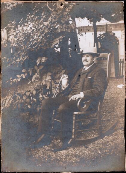 Gabriel Dupont assis dans un jardin